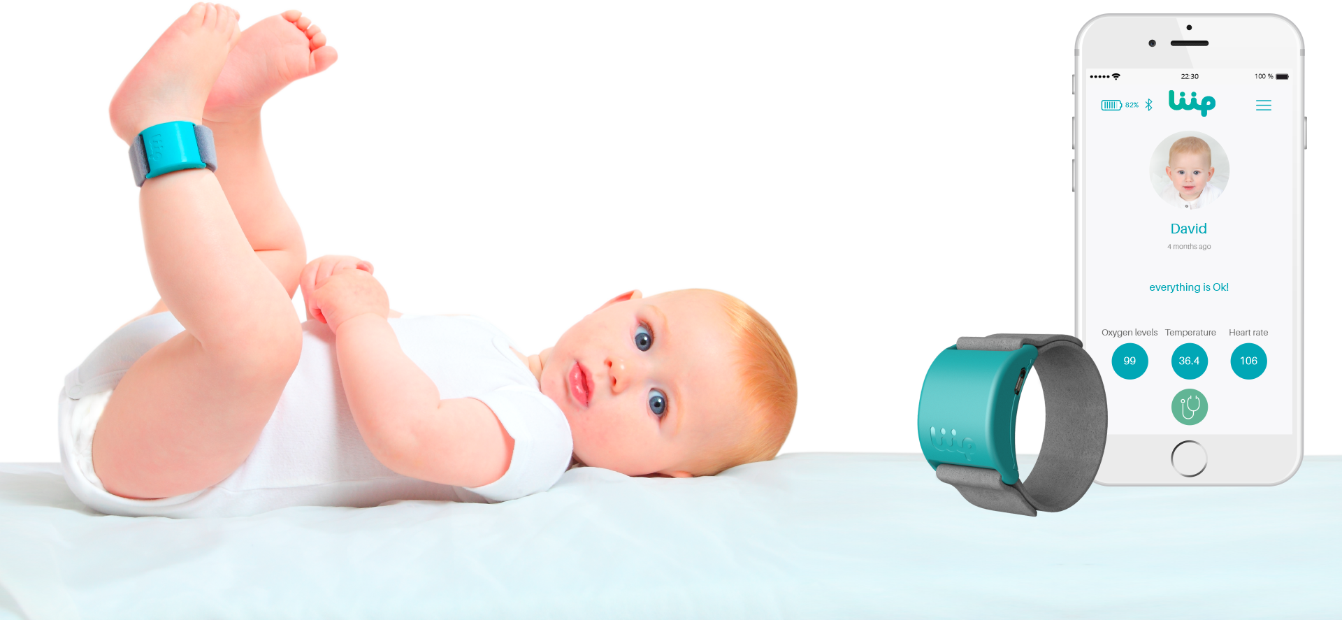 Baby mit blauen Fußbändern, liegend. Telefon zeigt Babydetails, Werte: Sauerstoff 99, Temp 36,4.