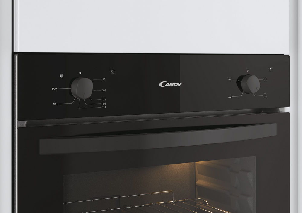 Panel de control de horno negro con la marca Candy, perillas y marcas de temperatura.