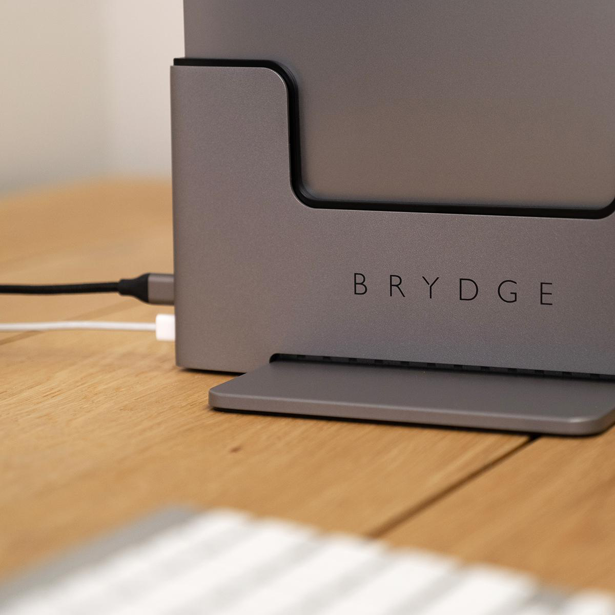 Nahaufnahme einer silbernen Ladestation mit dem Wort BRYDGE darauf. Ein Kabel ist eingesteckt.