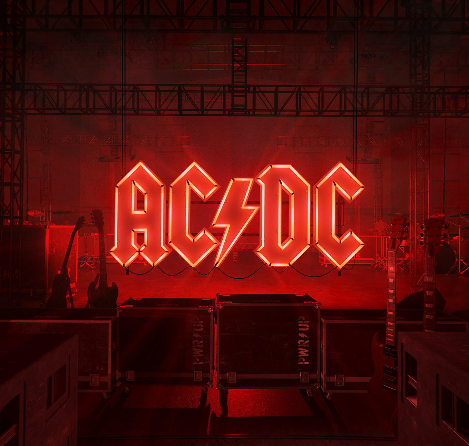 Enseigne au néon AC/DC sur scène, avec guitares et matériel de scène, éclairage rouge.