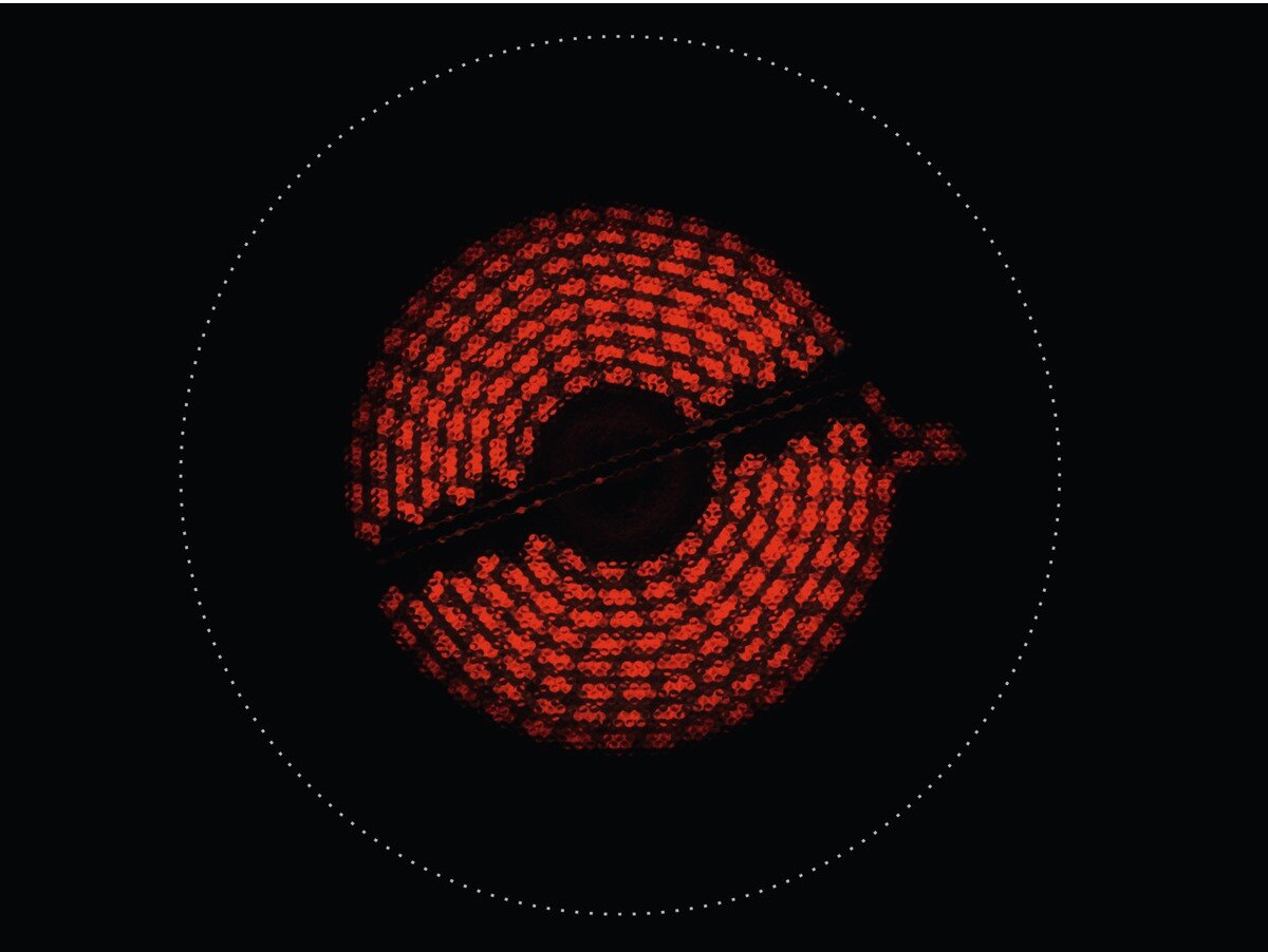 Red hotplate with a glowing circular pattern on a black surface.