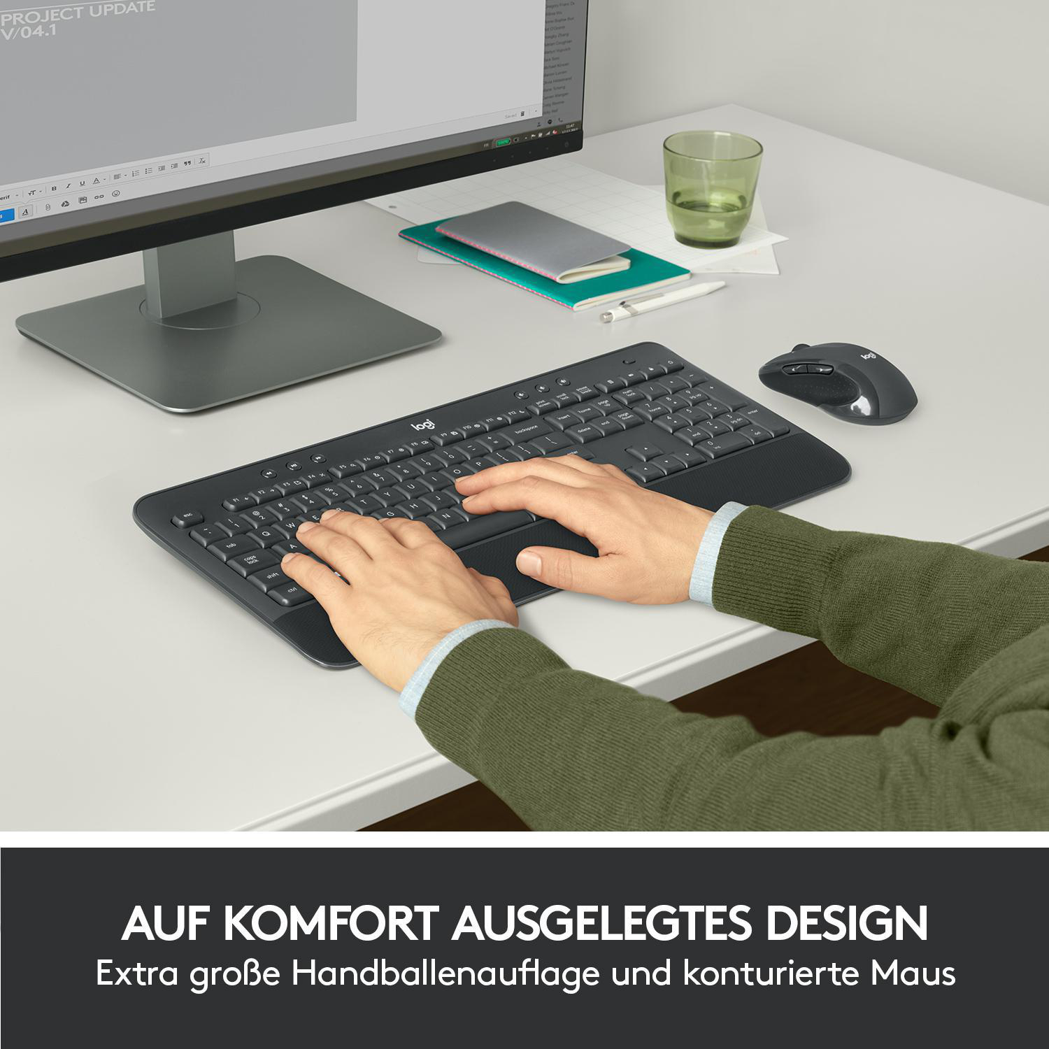 Eine Person mit Händen auf Tastatur und Maus auf einem weißen Schreibtisch, mit Text: „KOMFORT DESIGN“.