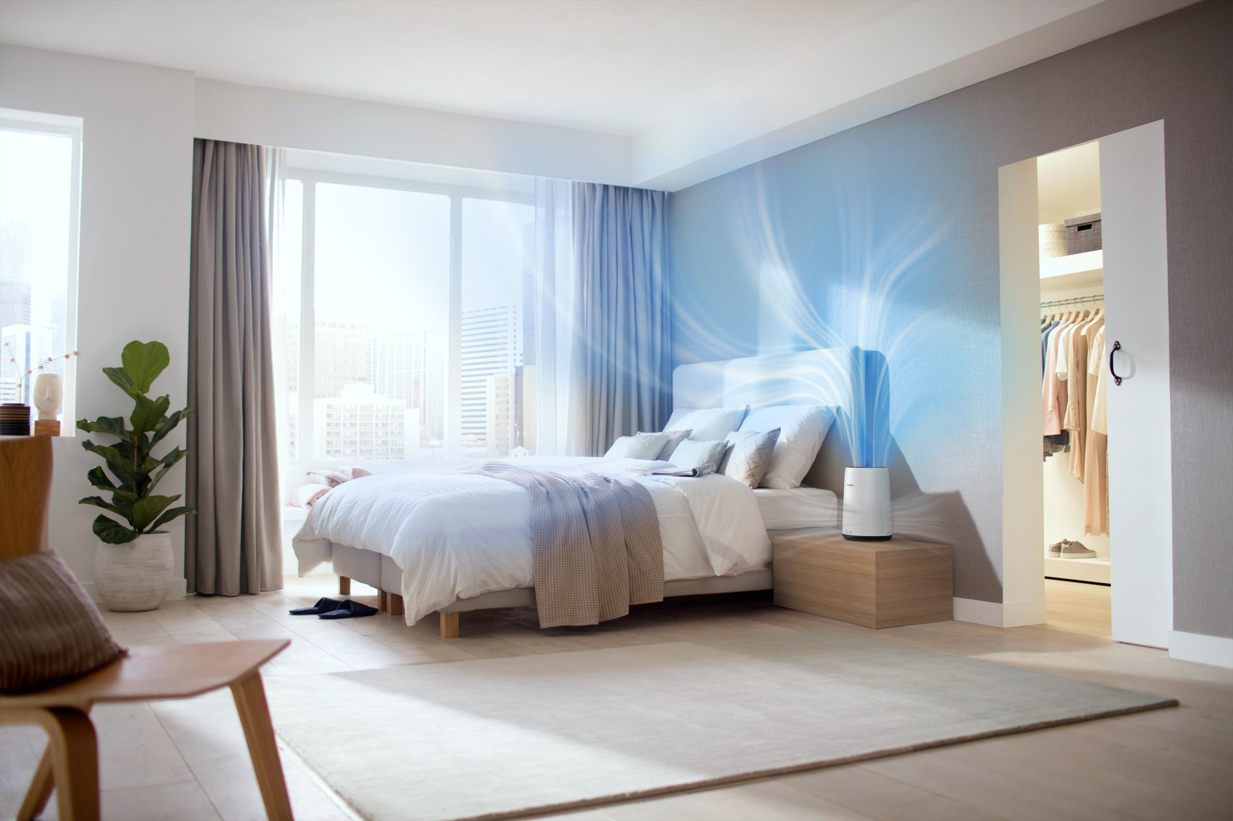 Schlafzimmer mit Bett, Fenster, Vorhängen, Luftreiniger und Kleiderschrank mit offenen Türen.