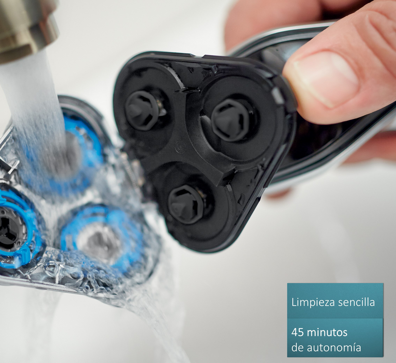 Primer plano de un cabezal de afeitadora bajo agua corriente. Texto: Limpieza fácil, 45 minutos de autonomía.