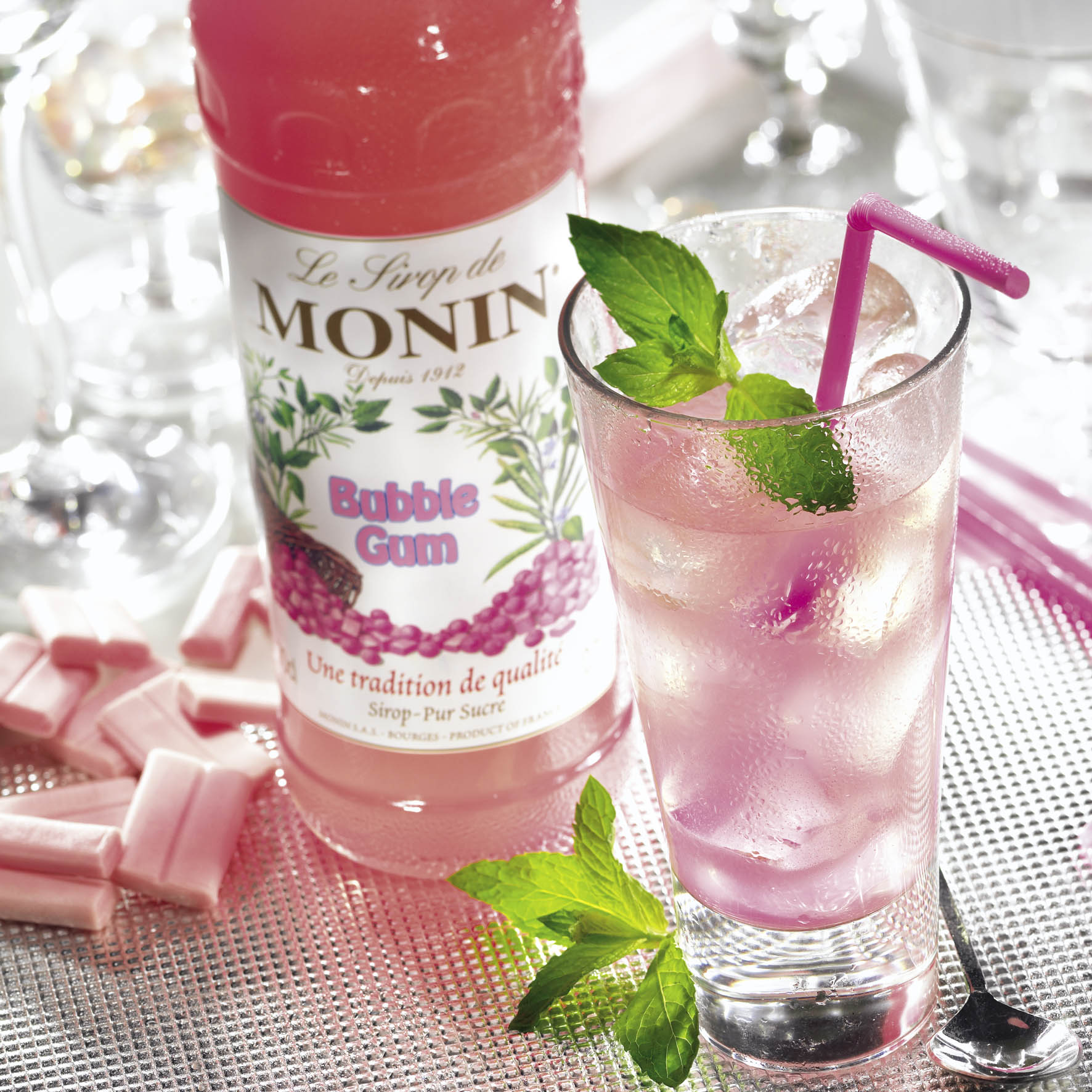 Rosa Bubble-Gum-Getränk in einem hohen Glas mit Minze und Eis.