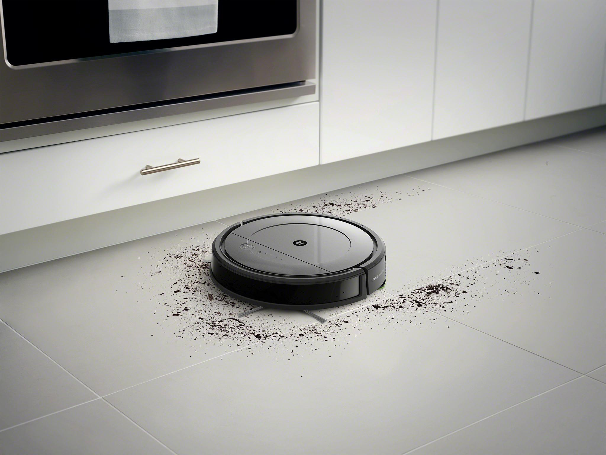 Roboter-Staubsauger auf Fliesenboden, reinigt Schmutz.