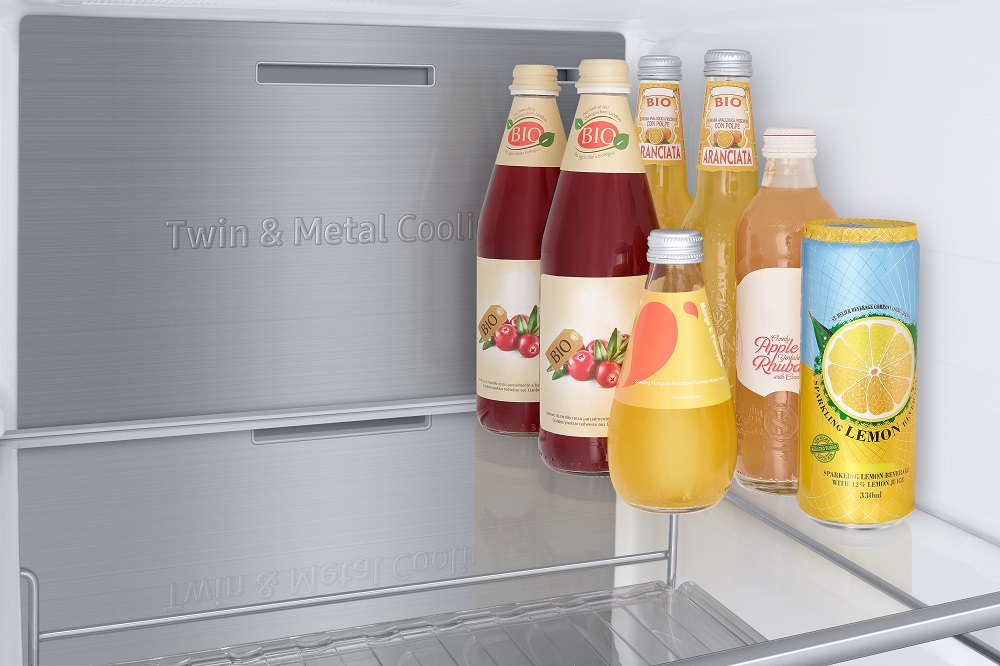 In einem Kühlschrank befinden sich mehrere Saftflaschen und eine Limonadendose auf einem Regal.