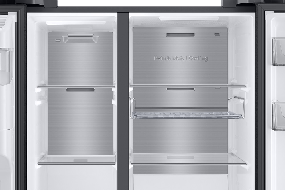Innenraum eines geöffneten Samsung-Kühlschranks mit Regalen, Metallplatten und Schubladen.