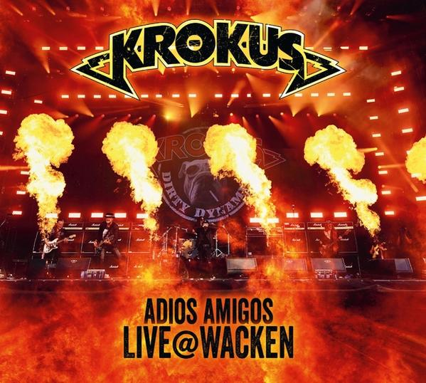Albumcover: Krokus, Adios Amigos Live @ Wacken. Eine Band spielt auf der Bühne mit Flammen.