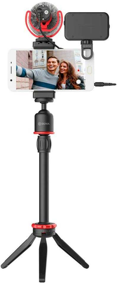 Un smartphone sur un trépied avec un microphone, enregistrant deux personnes. Le fond est flou.