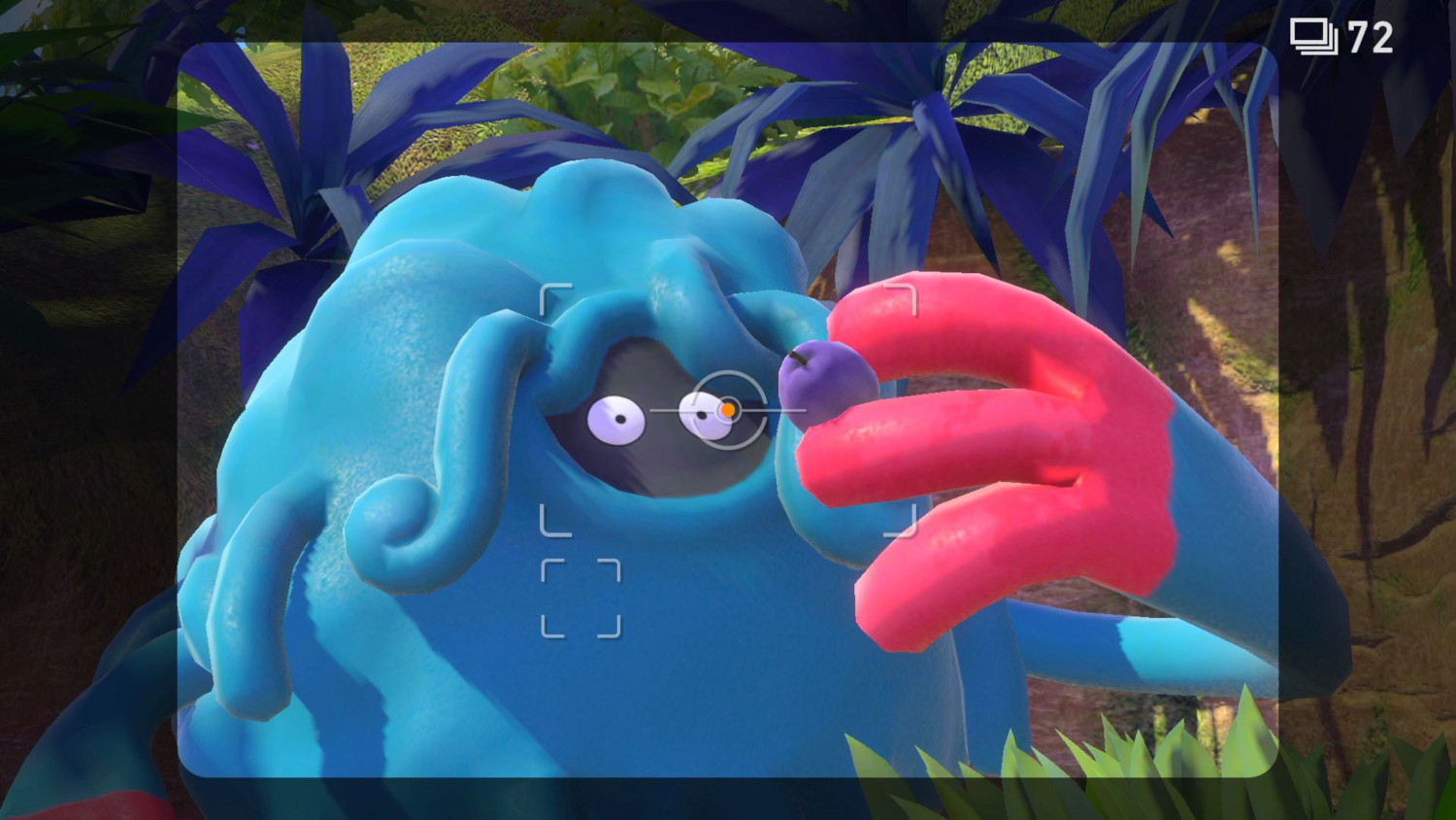 Een screenshot van een blauw wezen dat een paarse bes vasthoudt, in een bos.
