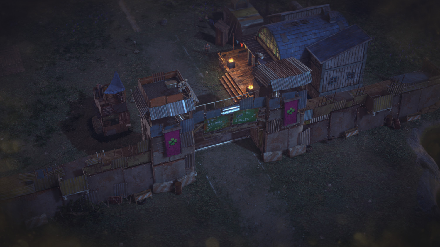 Overhead view of a post-apocalyptic scene with a gate, buildings, and a dirt road. Dark, moody.