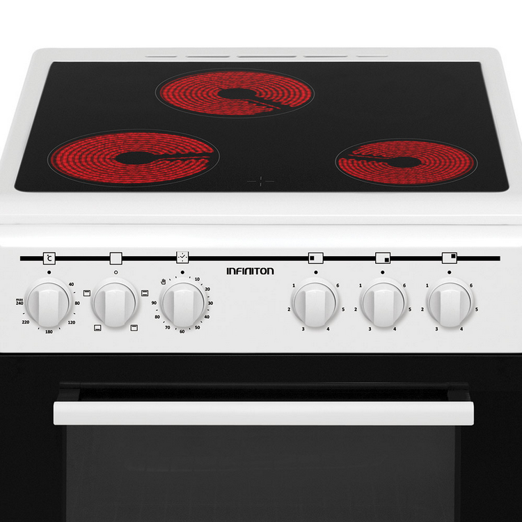 Primer plano de una placa de cocina blanca con tres fuegos rojos y mandos de control.