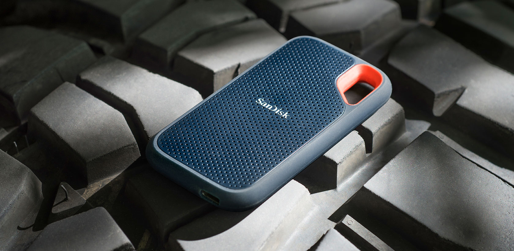Dunkelblaue externe Sandisk-Festplatte auf strukturierter Oberfläche.