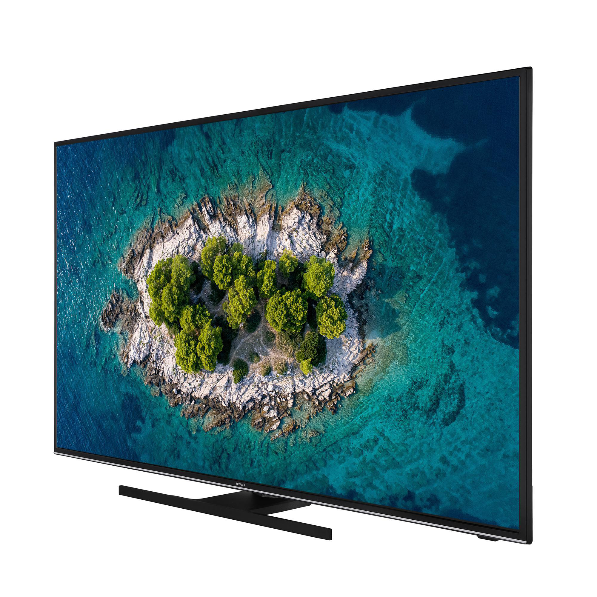 Ein großer Fernseher, der eine tropische Insel zeigt. Er steht auf einem Ständer.