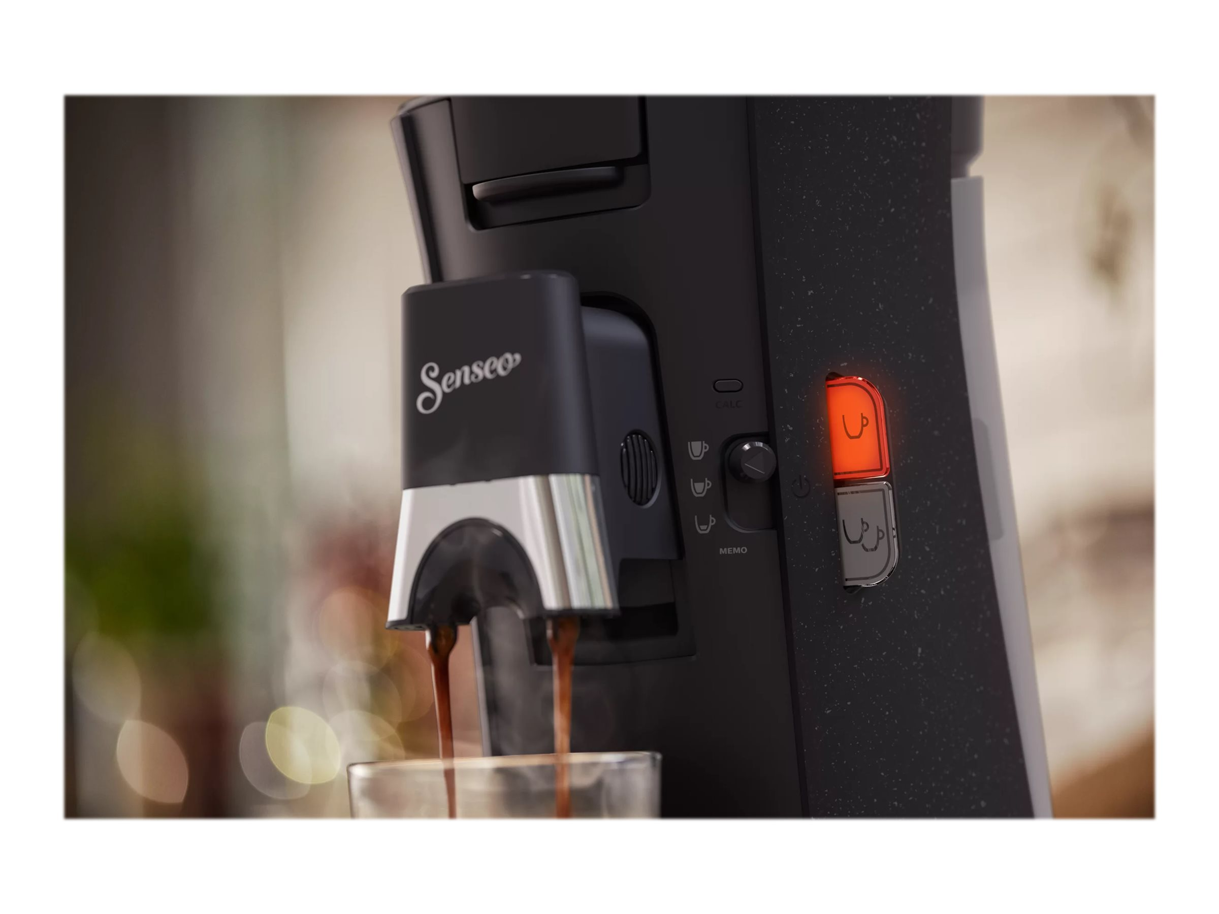 Schwarze Senseo Kaffeemaschine mit Dampf und einer sich füllenden Tasse.