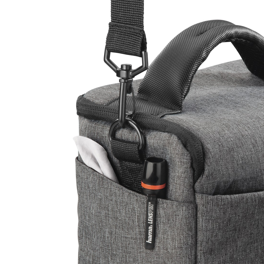 Graue Kameratasche mit einer Tasche, die ein weißes Tuch und einen Objektivstift enthält.