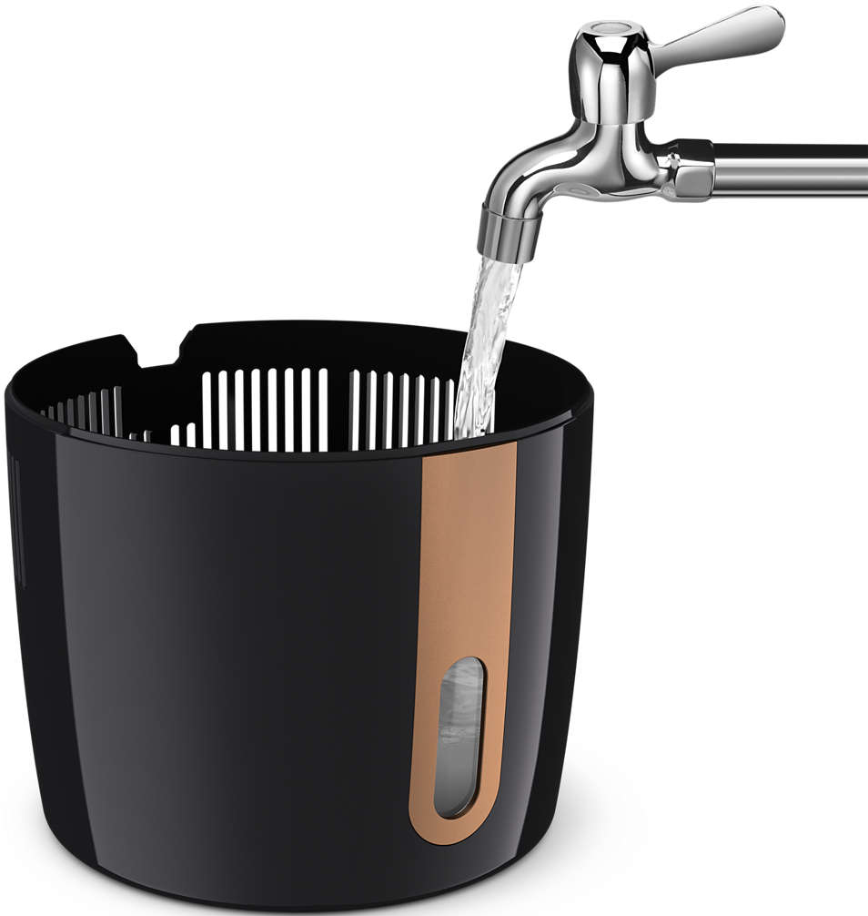 L'acqua scorre da un rubinetto in un contenitore nero con una striscia color rame.