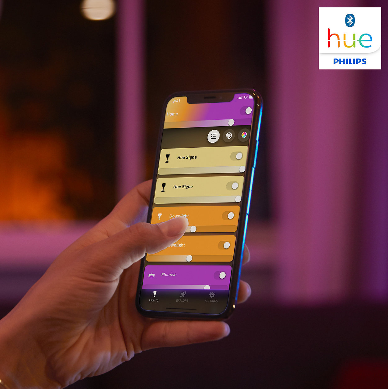 Hand, die ein Telefon mit App-Steuerung für ein Hue-Beleuchtungssystem hält.