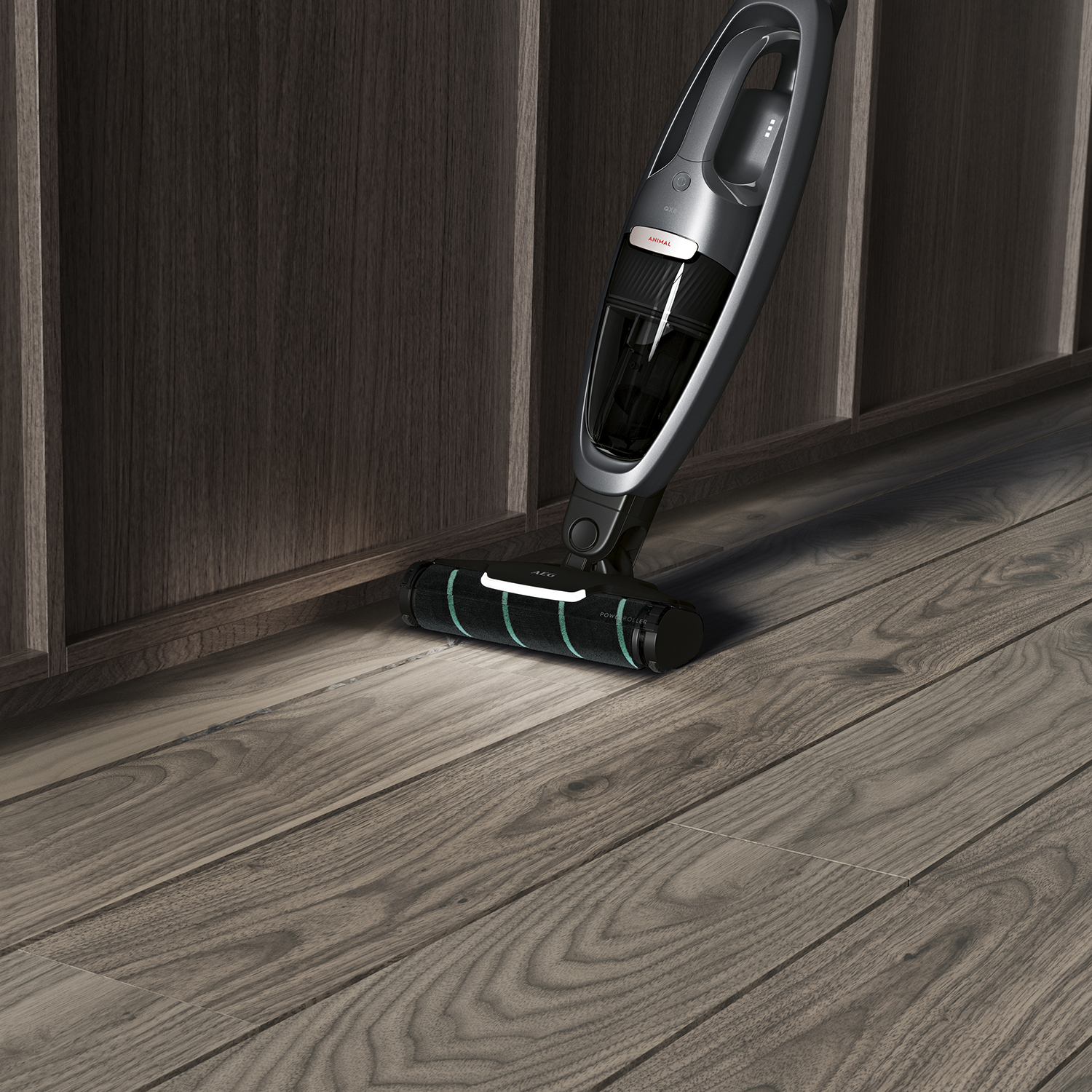Een grijze en zwarte draadloze stofzuiger staat op een houten vloer.