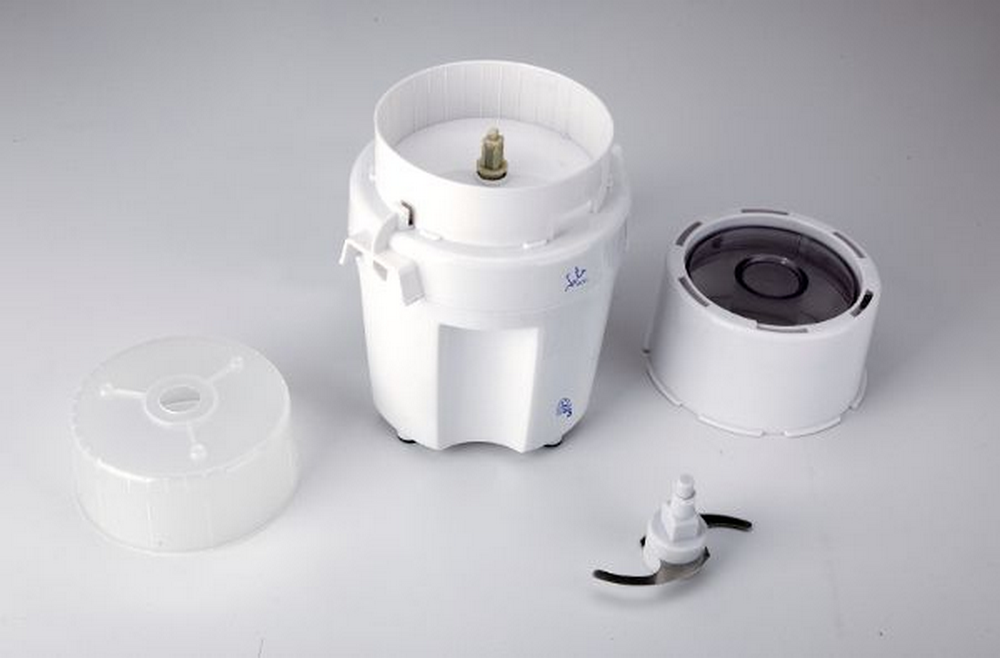 Un procesador de alimentos blanco desmontado con sus piezas dispuestas. Componentes incluyen cuchilla, tapa y base.