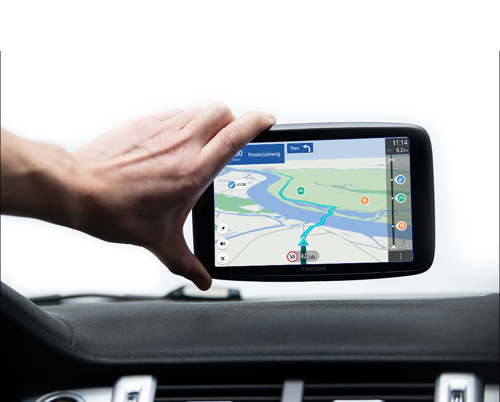 A hand holding a GPS device, displaying a route on a screen inside a car.
