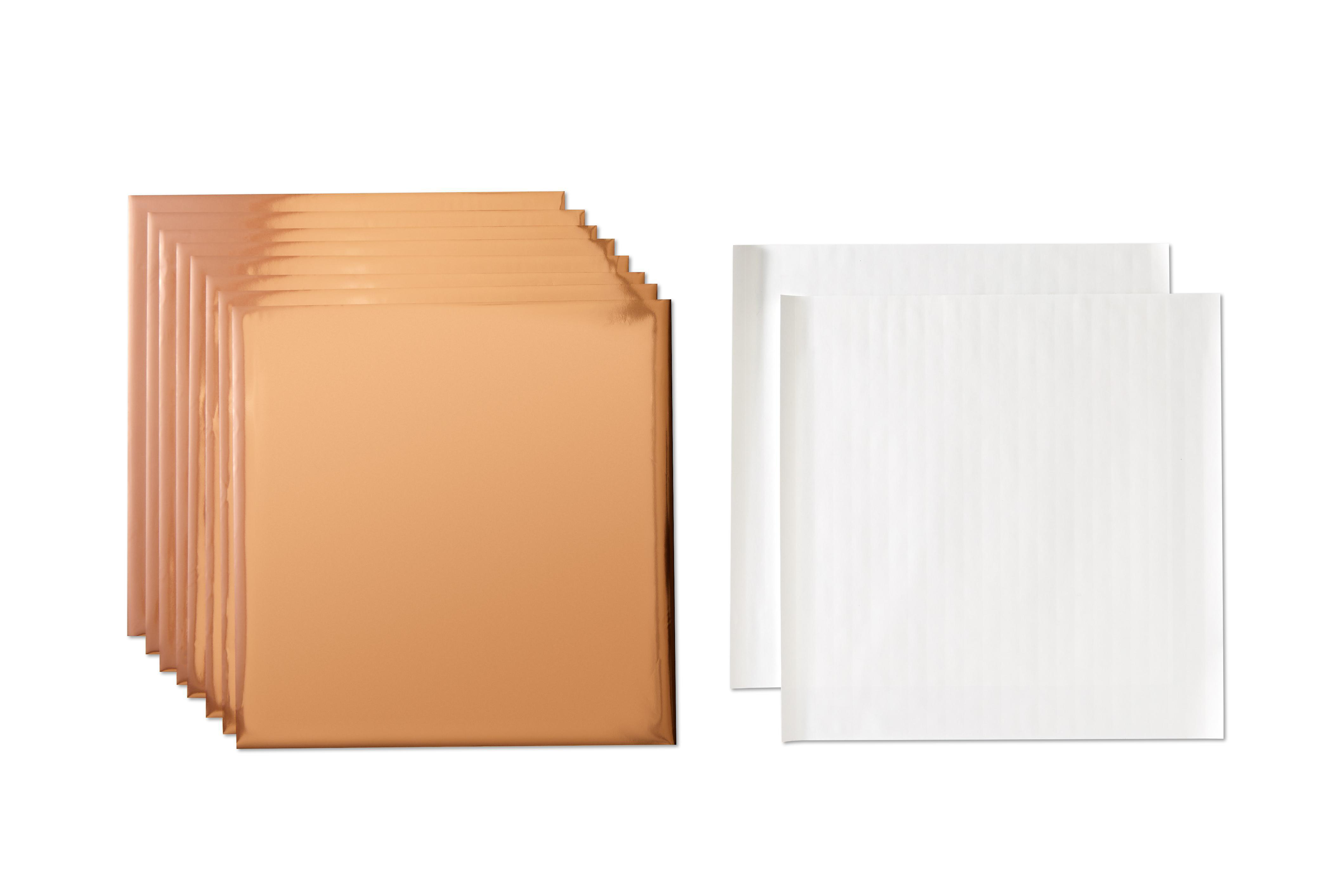 Das Bild zeigt zwei Papierstapel. Ein Stapel ist bronzefarben, der andere weiß. Der Hintergrund ist weiß.