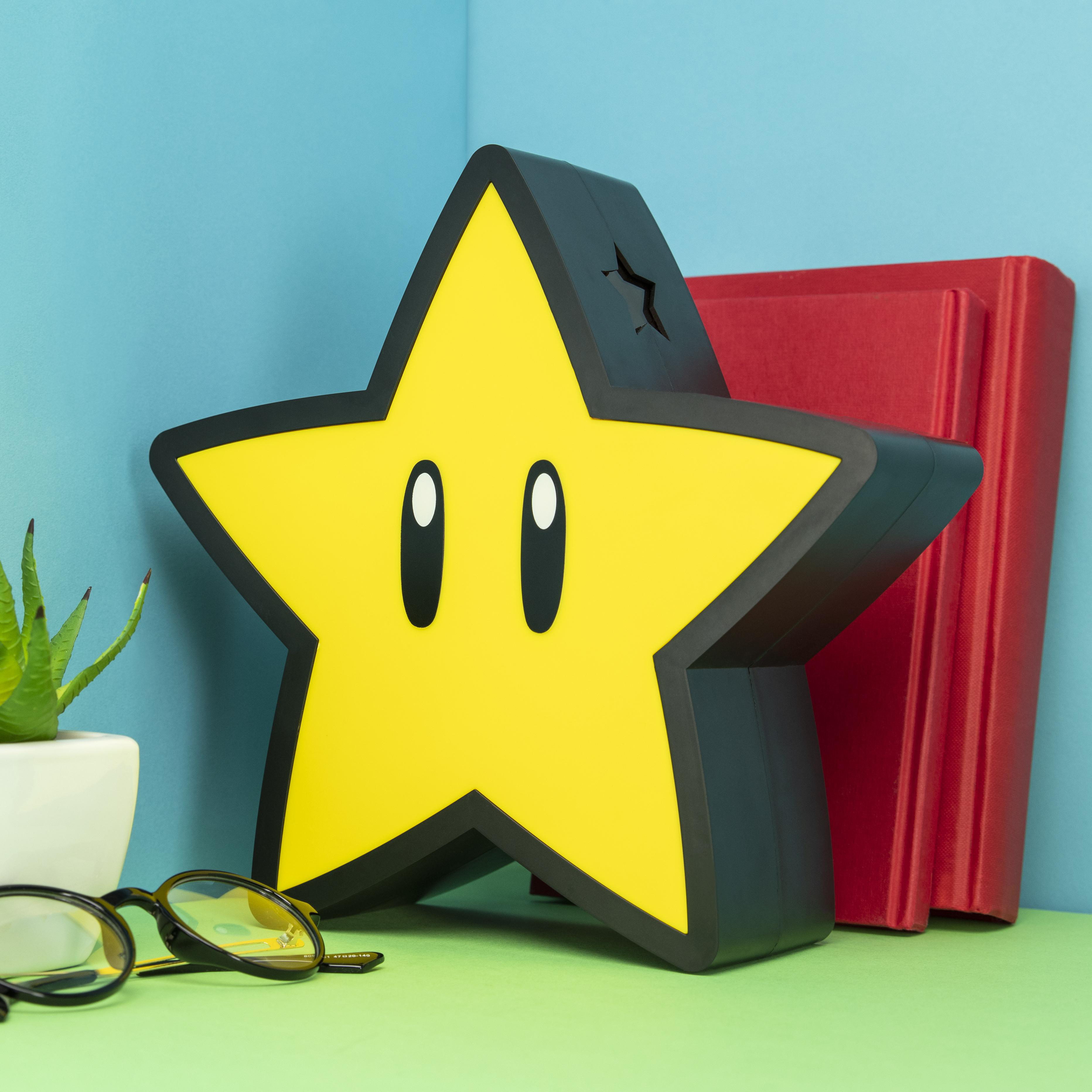 Eine gelbe Sternlampe mit Gesicht steht neben zwei roten Büchern.
