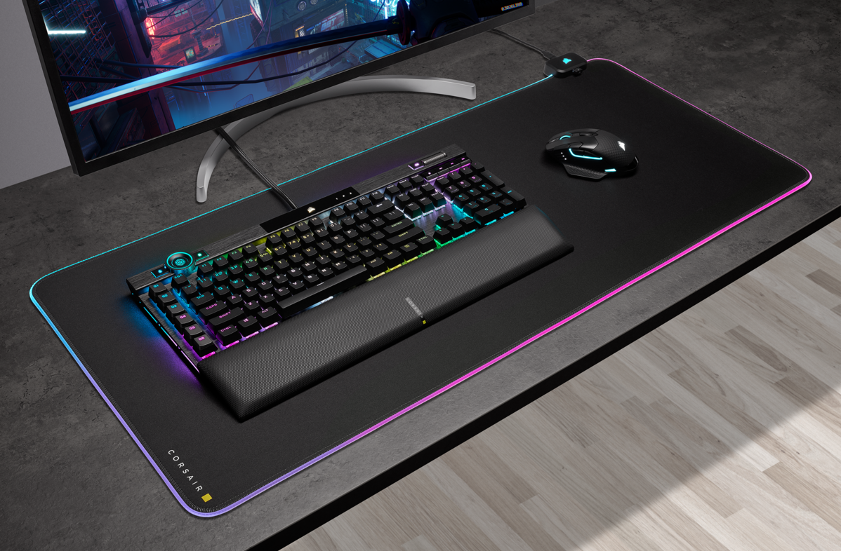 Configuration de jeu avec clavier, repose-poignet, souris et moniteur. Le clavier est éclairé.