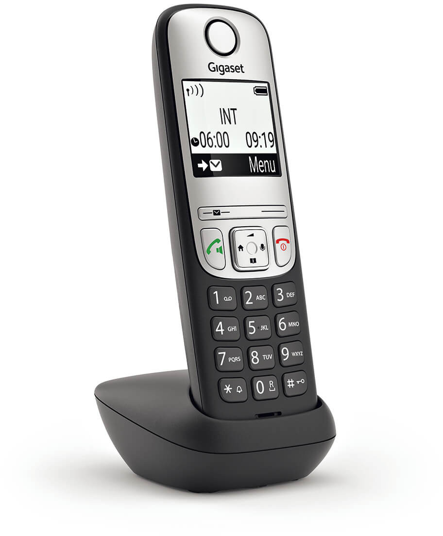 Vezeték nélküli telefon a töltőjén. A telefon kijelzője időt mutat, a töltő fekete.
