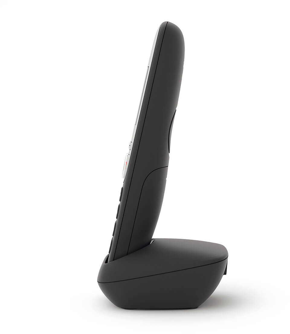 Fekete vezeték nélküli telefon töltőállomáson, oldalsó nézet, fehér háttérrel.