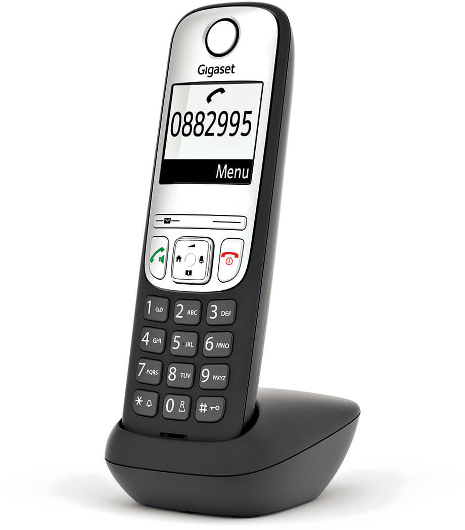 Egy fekete-ezüst vezeték nélküli telefon a fekete töltőállomásán. A telefon képernyője egy telefonszámot mutat.