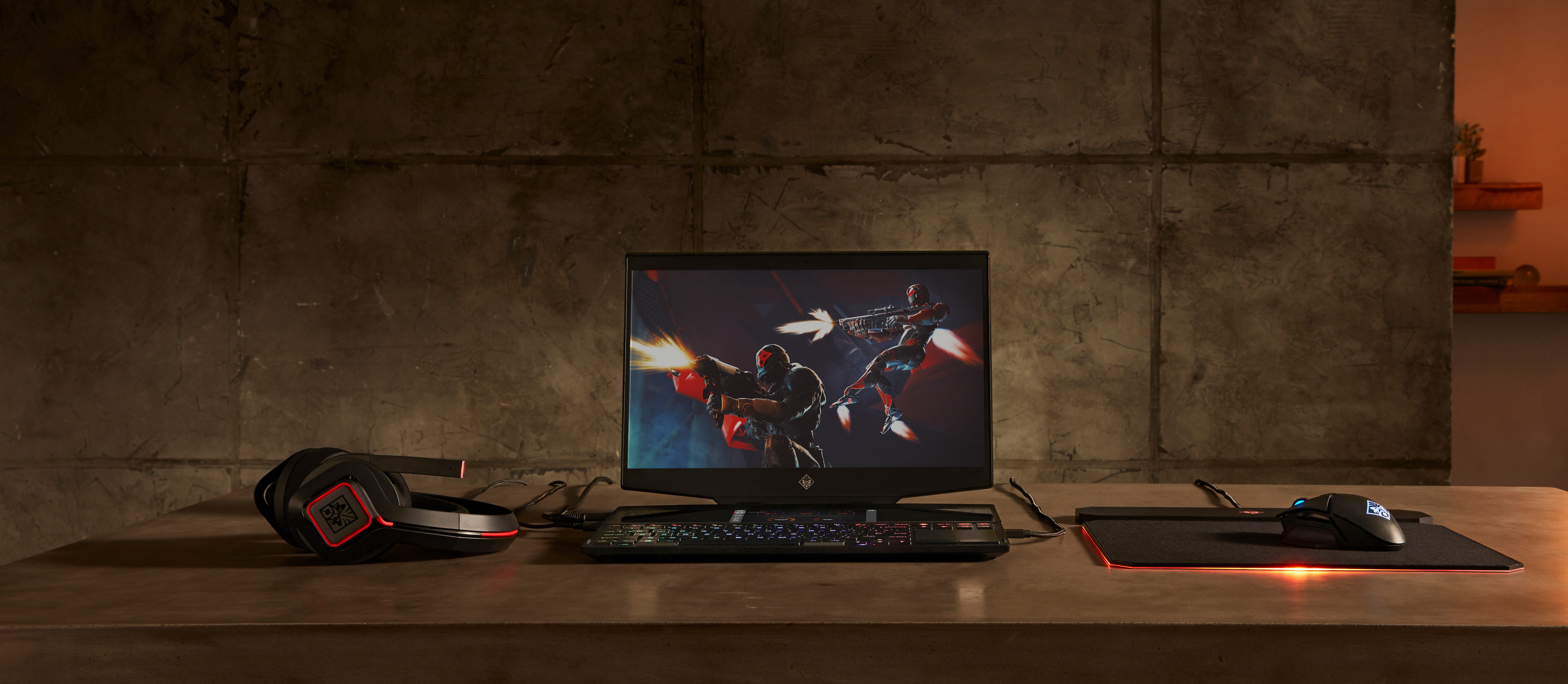Configuración de juego con monitor, teclado, ratón y auriculares HP. Fondo de pared oscuro.