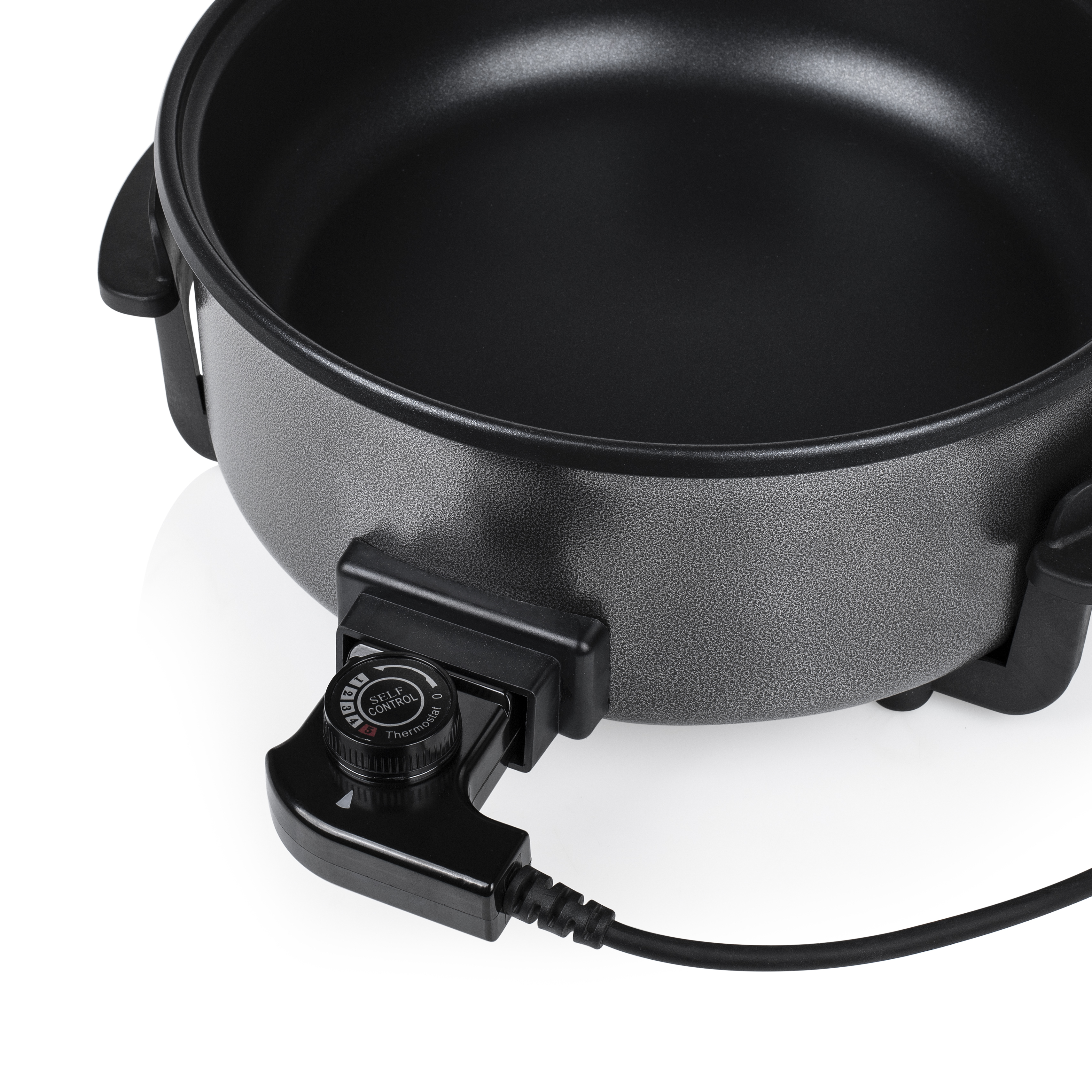 Primer plano de sartén eléctrica con dial de control de temperatura. Cable negro conectado.