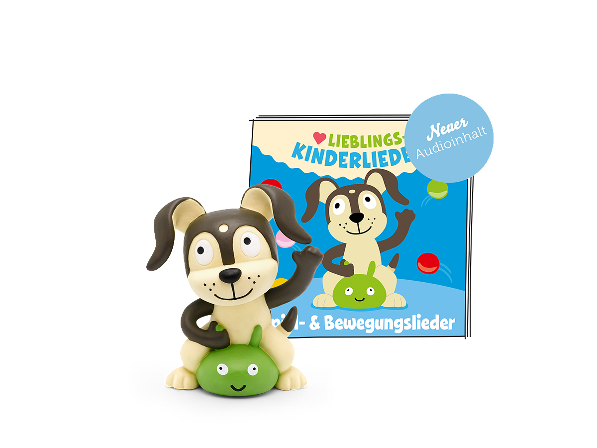 Hundespielzeug auf grüner Basis und ein Buch mit einem Hund darauf.