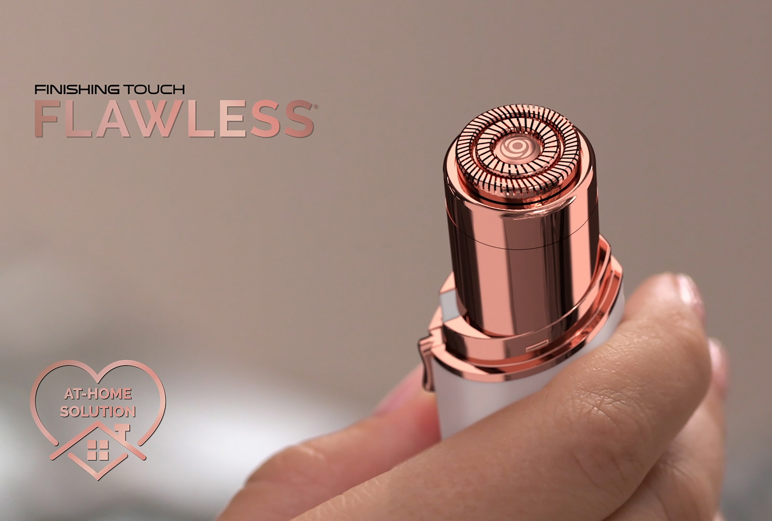 Hand hält ein roségoldenes und weißes Haarentfernungsgerät. Text: FINISHING TOUCH FLAWLESS, AT-HOME SOLUTION.