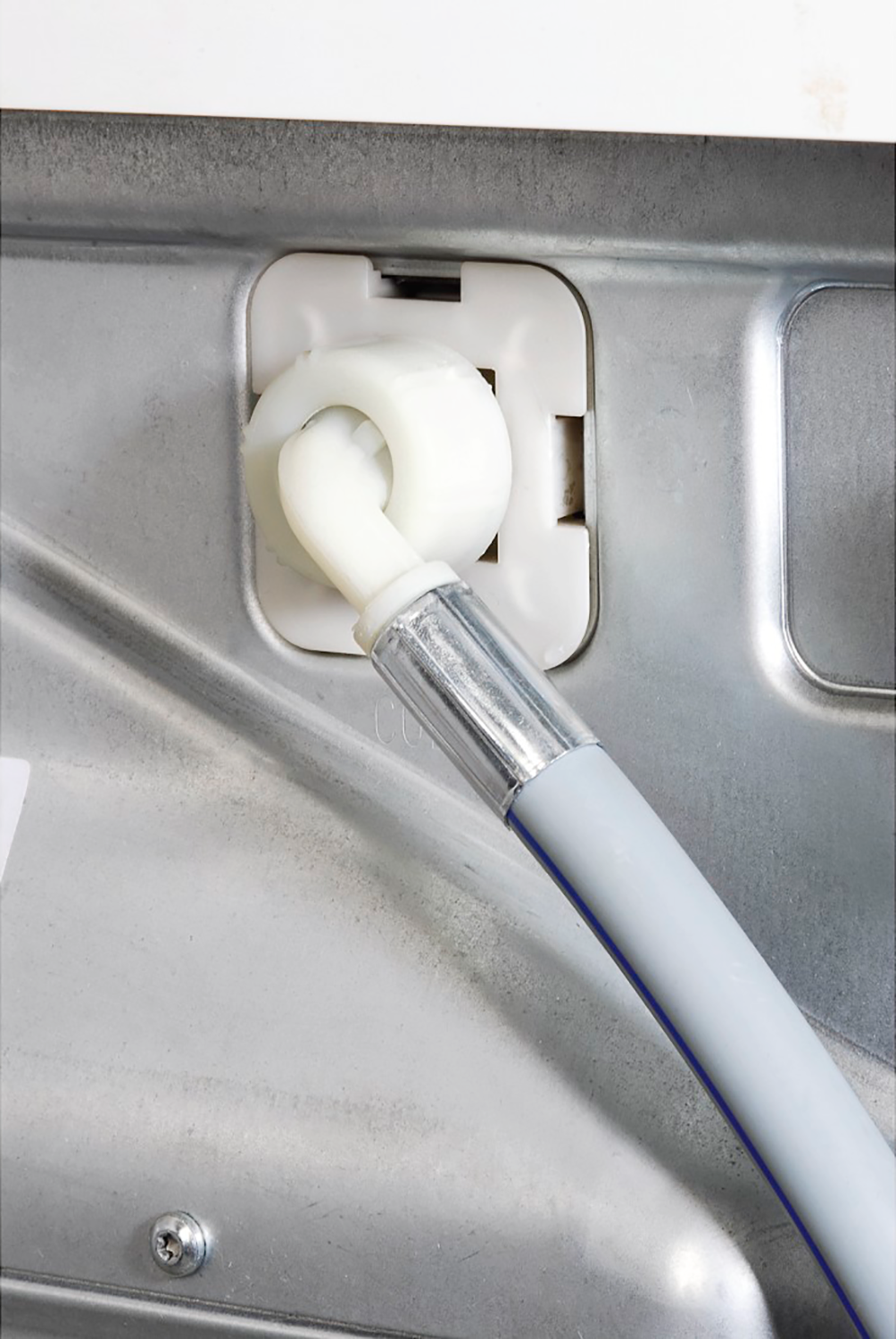 Een close-up van een witte wasmachine-waterinlaat met een aangesloten grijze slang.