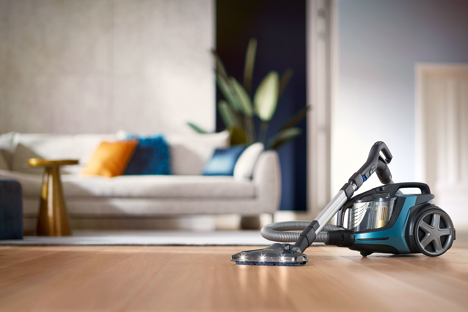 Oturma odasında ahşap bir zeminde bir elektrikli süpürge.