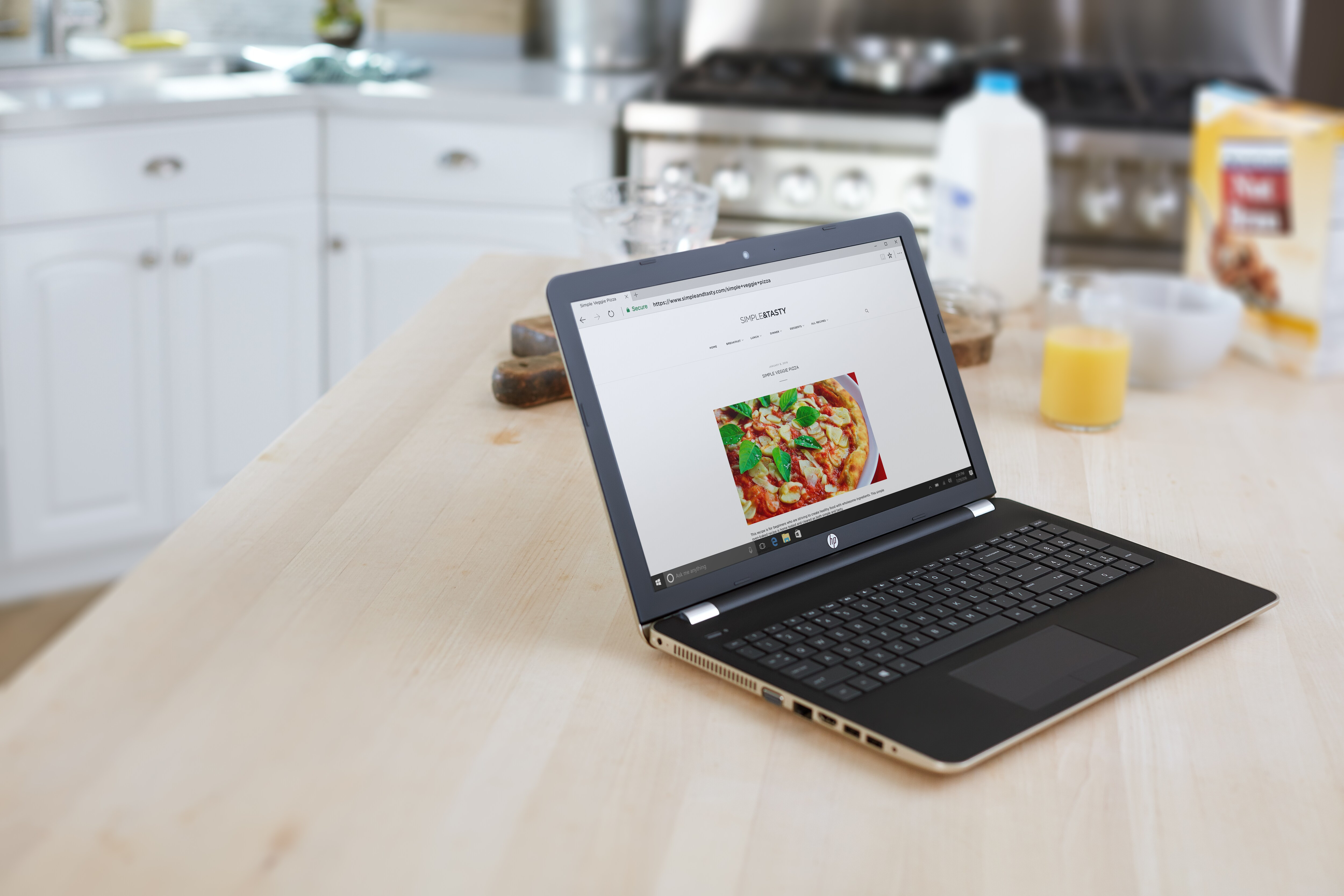 Ekranda pizza resmi olan dizüstü bilgisayar. Mutfak arka planı. Ahşap bir masada dizüstü bilgisayar.