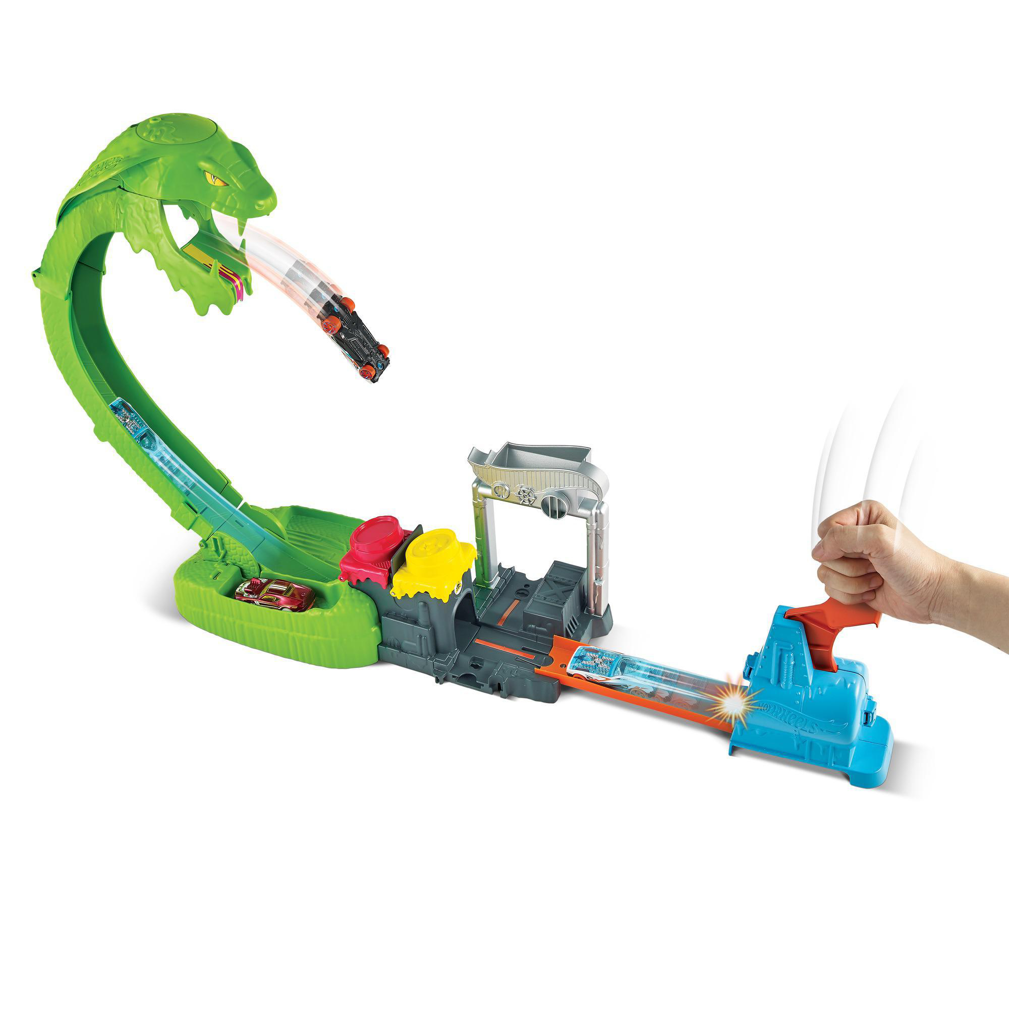 Eine Hot Wheels-Strecke mit einem grünen Schlangenkopf, der Autos startet. Eine Hand aktiviert den Werfer, der Autos durch die Strecke schickt.