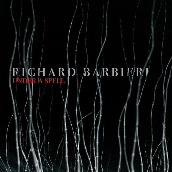 Albumcover mit schwarzem Hintergrund und vertikalen Linien. Text: 'Richard Barbieri Under a Spell'.