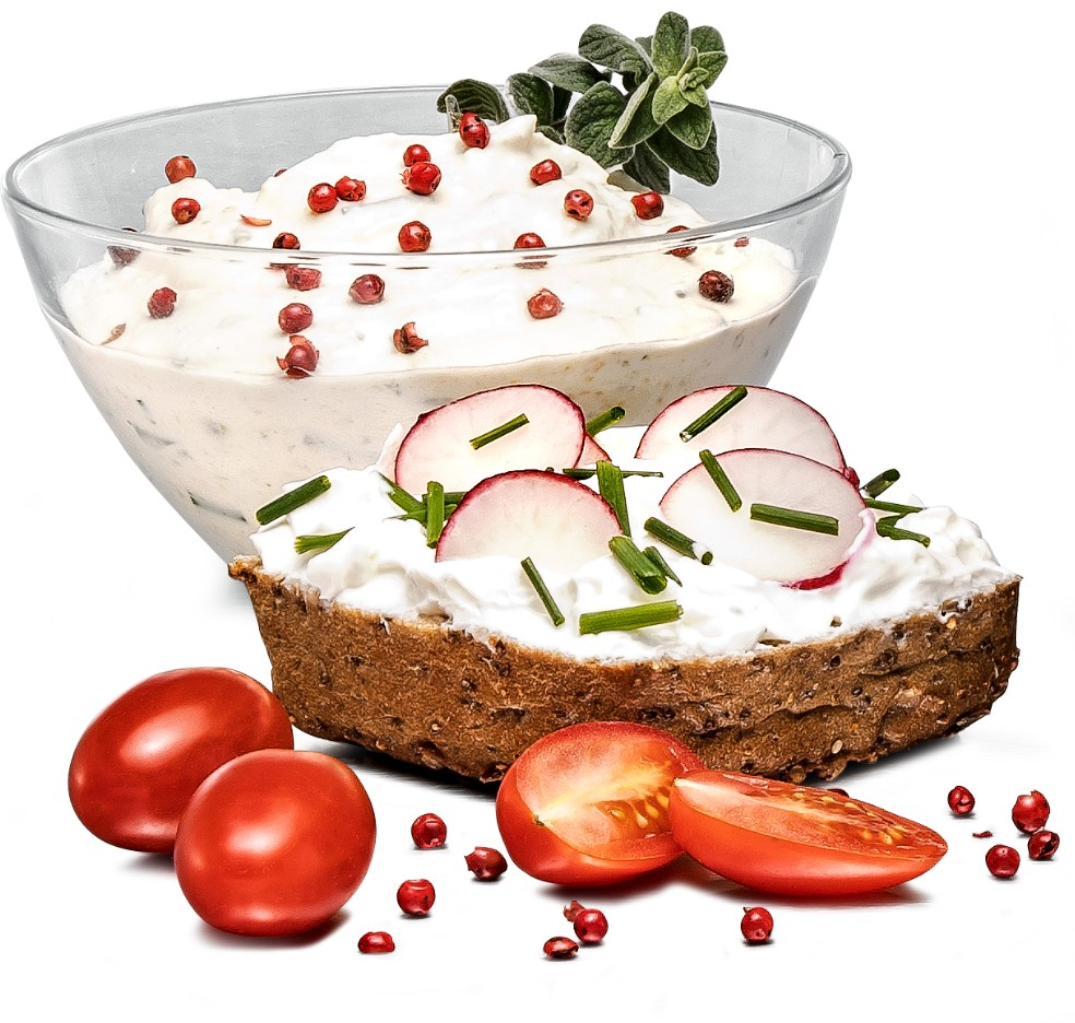 Cremiger Dip in einer Schüssel, mit Brot, Tomaten und roten Pfefferkörnern.