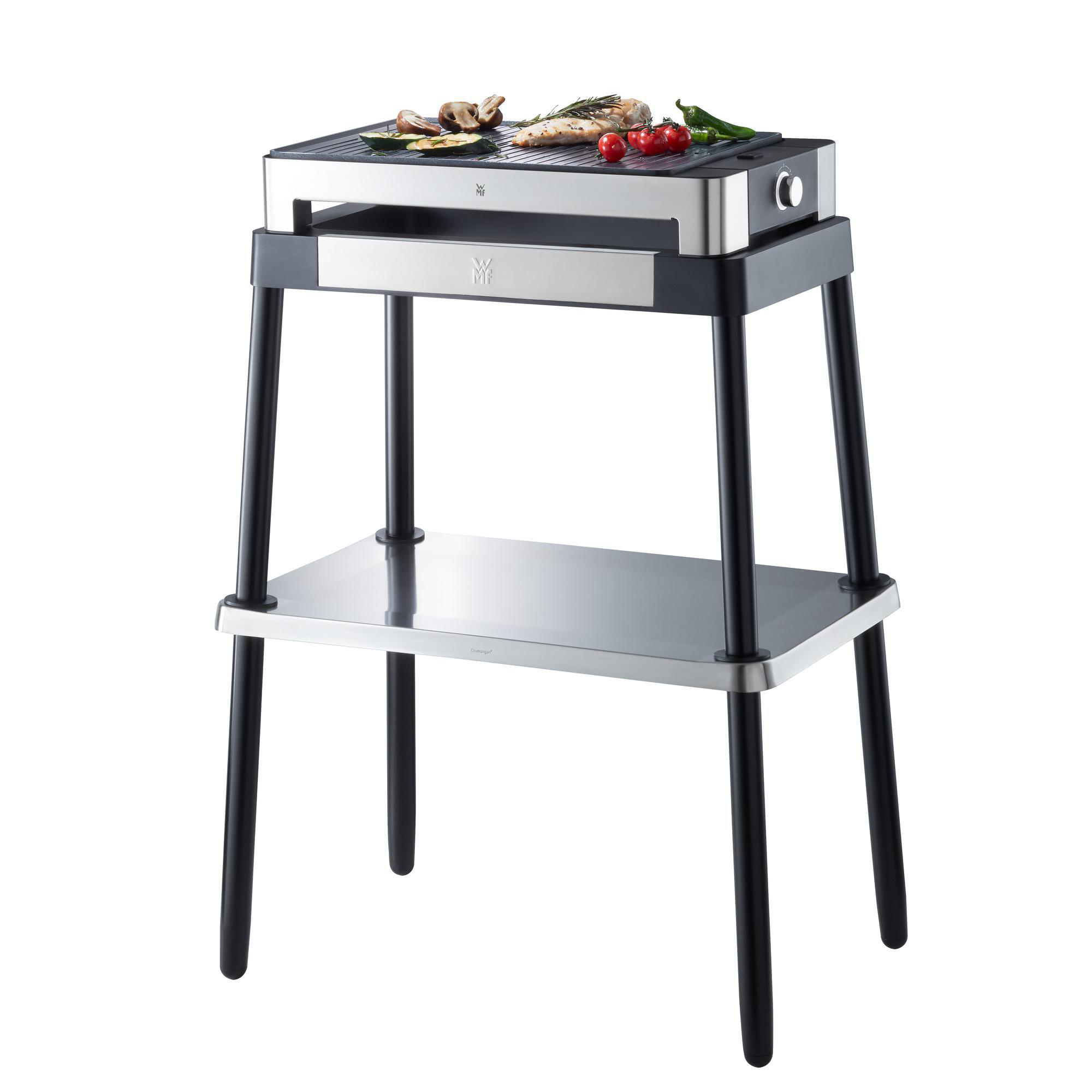 Silberner und schwarzer WMF-Grill mit Essen oben, schwarzem Ständer unten.
