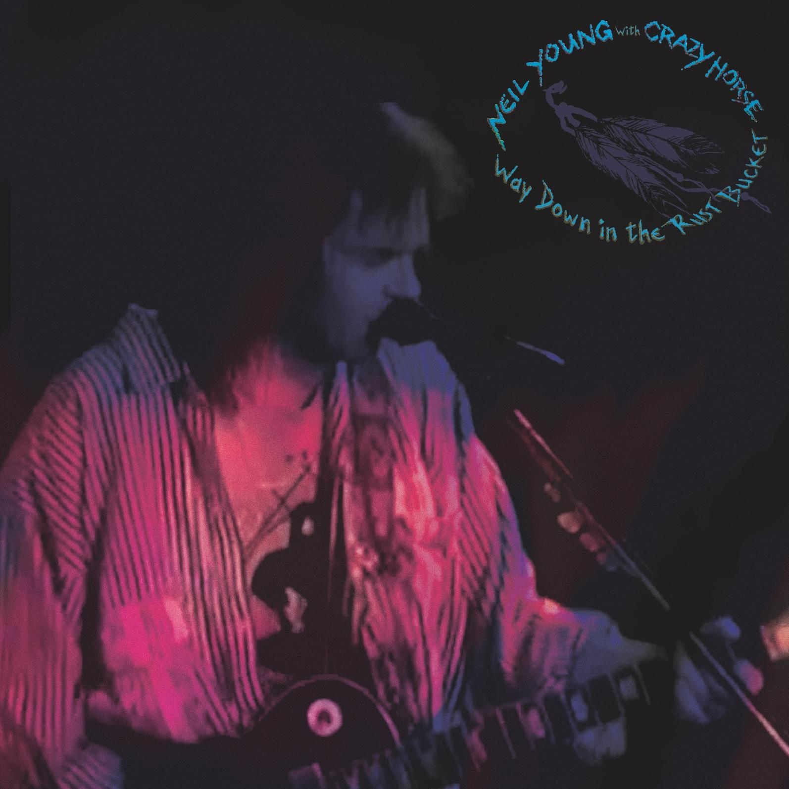 Neil Young gitározik a színpadon. Szöveg: Way Down in the Rust Bucket.