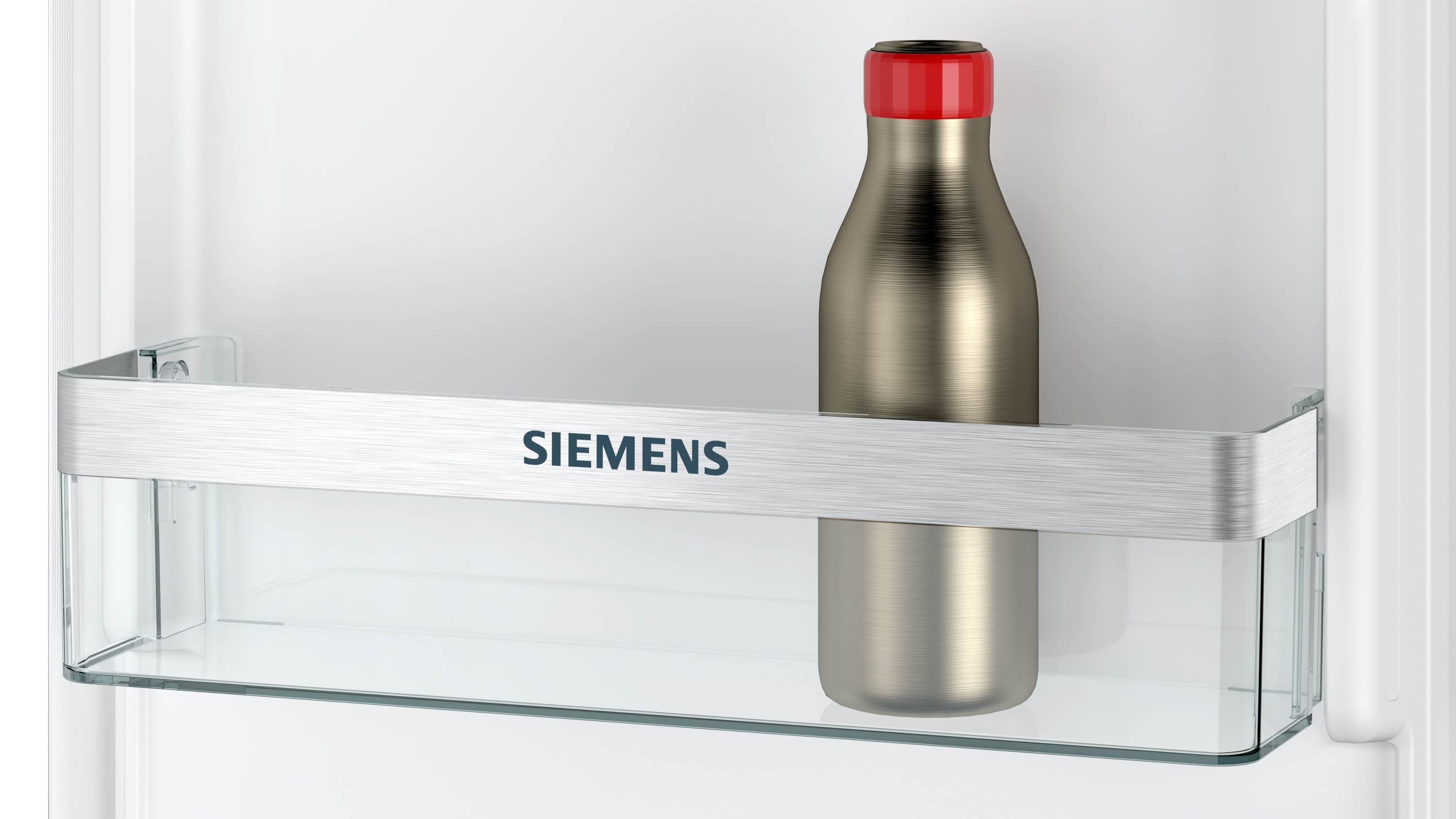 Silberne Flasche mit roter Kappe im Kühlschrankregal.