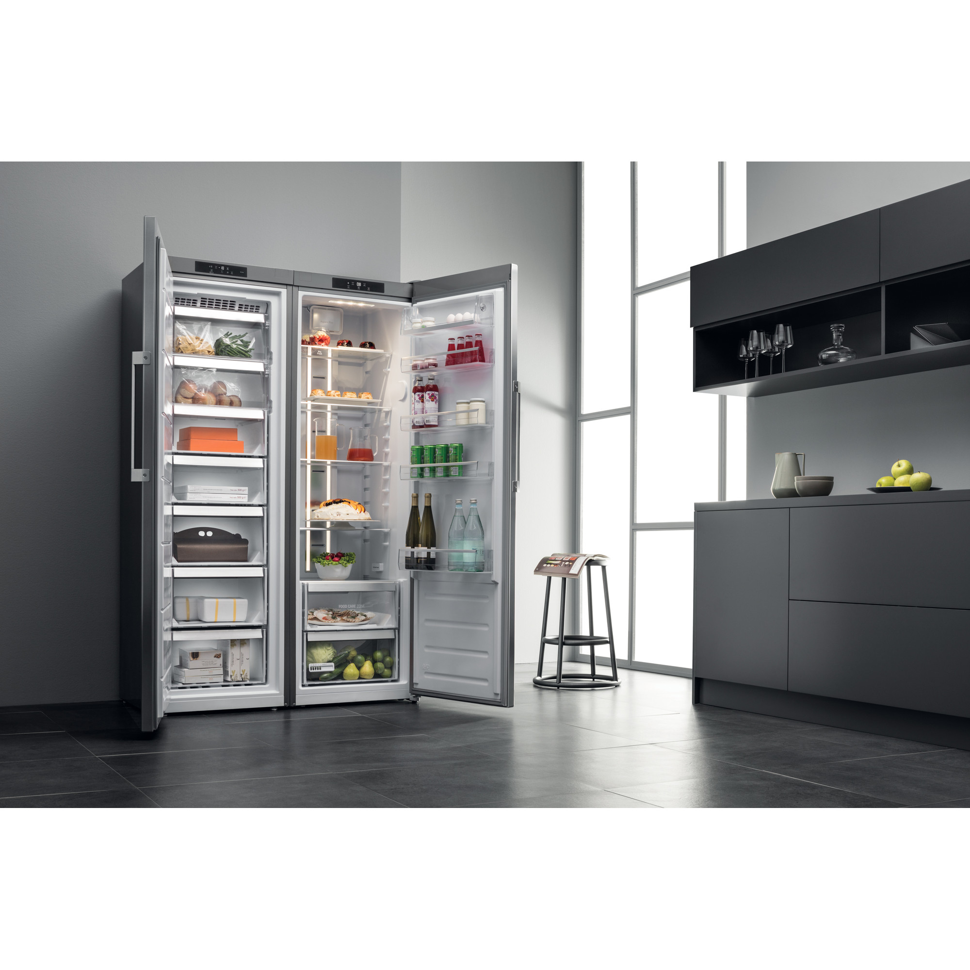 Eine Weitwinkelaufnahme einer modernen Küche mit einem Kühlschrank. Die Kühlschranktüren sind geöffnet.
