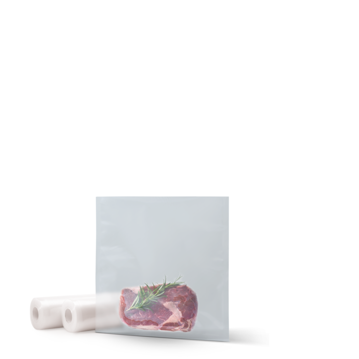 Rohes Steak mit Rosmarinzweig in klarer Plastiktüte und Vakuumrollen.