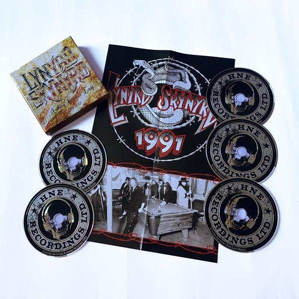 Lynyrd Skynyrd CD und Merchandise. Eine Box, mehrere CDs und ein Poster mit einer Schlange.