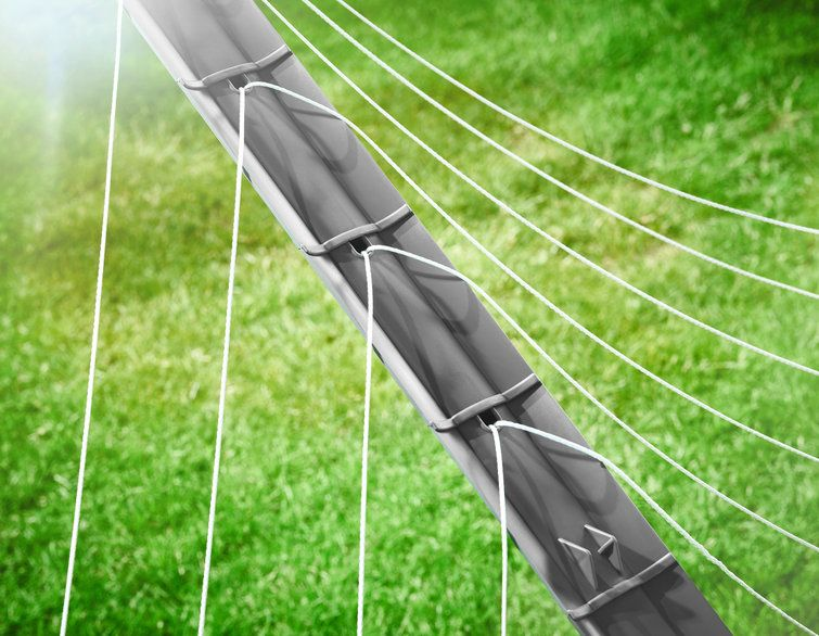 Nahaufnahme eines Fußballtornetzes mit grünem Gras im Hintergrund und Sonnenlicht.