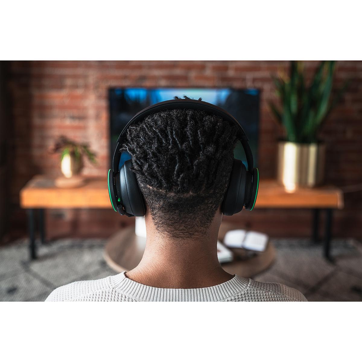 Eine Person, die ein schwarz-grünes Gaming-Headset trägt.